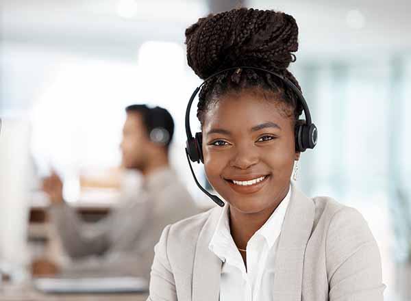 Woman with headphones and microphone looking at the viewer.