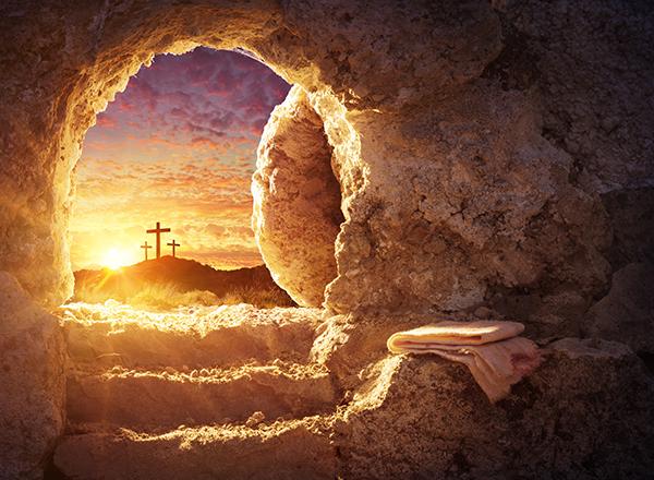 Image looking out from an open tomb, seeing sunrise and crosses in the distance