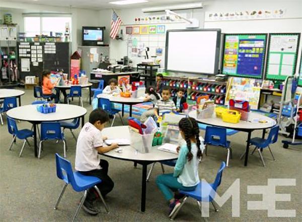 Students seated at tables in a classroom