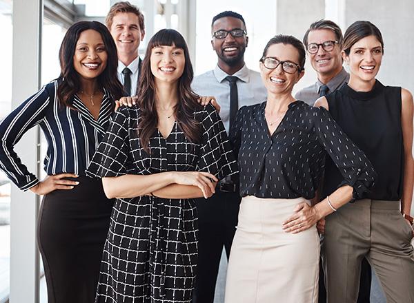 A diverse group of office professionals smiling.