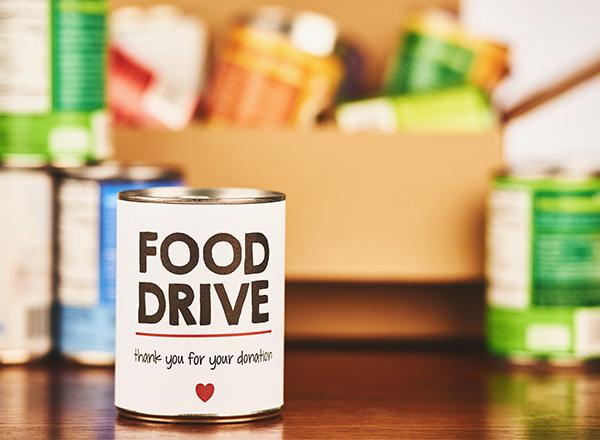 Food Drive canned goods collection with filled cardboard box.