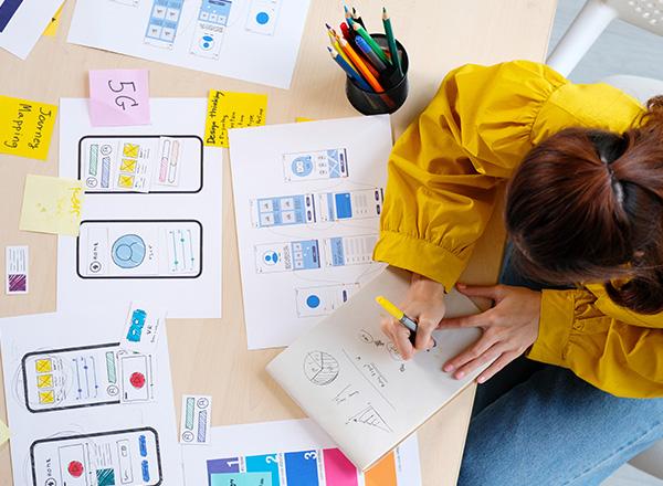 Overhead view of young woman web designer planning out web structure.