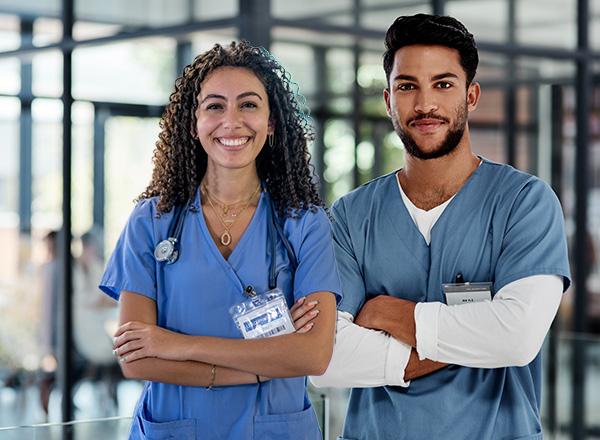Two nurses standing together with arms crossed.