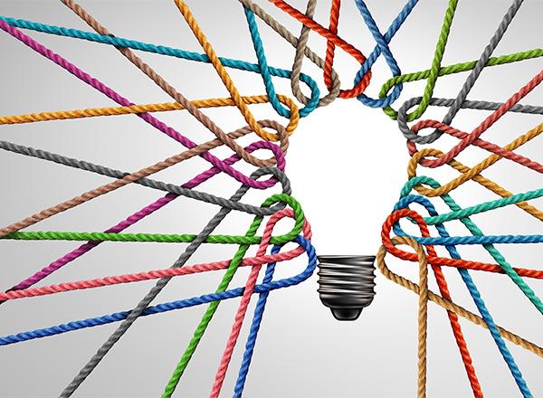 Looped pieces of colored string outlilning a lightbulb shape and radiating out to the edges of the frame.