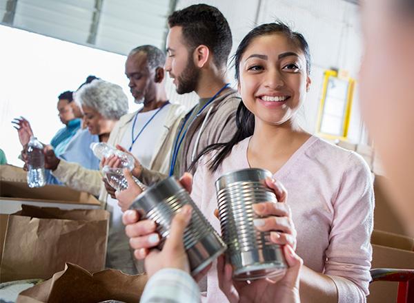 Volunteers packing cans of food.