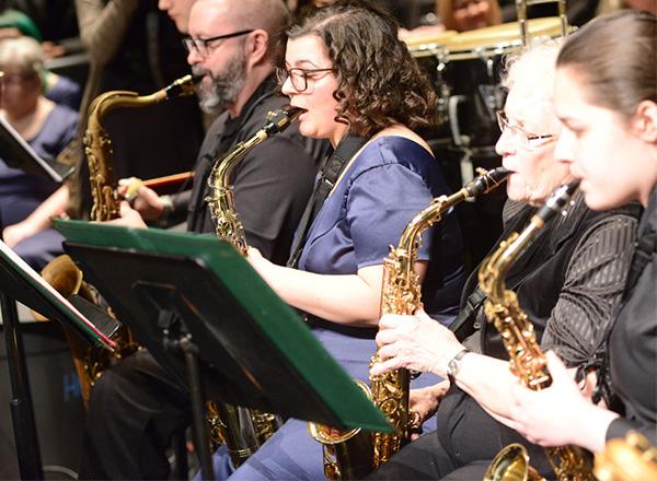 HFC Jazz musicians playing saxophone and reading sheet music.