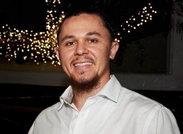 Nick Paseiro is wearing a white button down shirt.