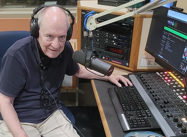 Joe Sullivan is sitting in the studio by the DJ equipment at WHFR.FM 89.3