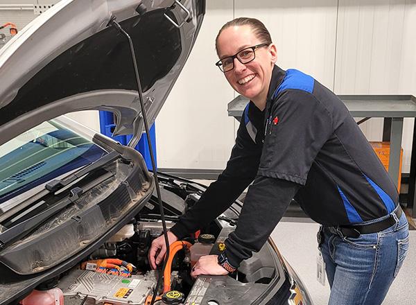 Photo of Ashley Smith checking a car engine.