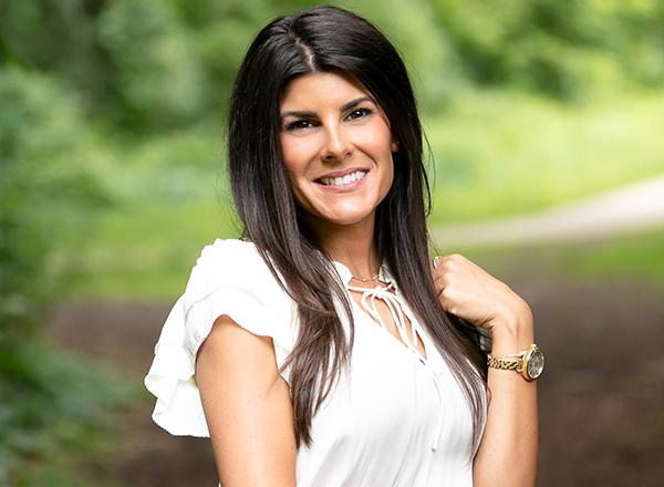 A headshot of Regina DeSanto. She has long brown hair and is wearing a white blouse.