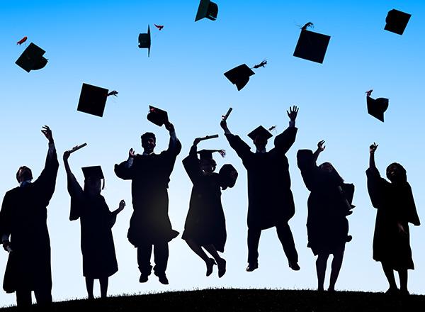 Silhouettes of graduates tossing caps on a blue gradient background.