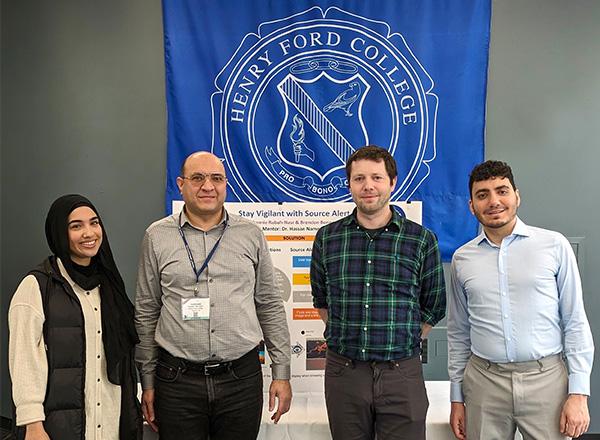 Photo of Hassan Nameghi and 3 pre-engineering students in front of the HFC seal.