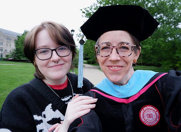 Dr. Chelsea Lonsdale in graduation attire on right, with her daughter to her left.