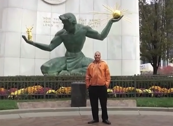 Anthony Brogdon standing in front of the Spirit of Detroit statue in Detroit