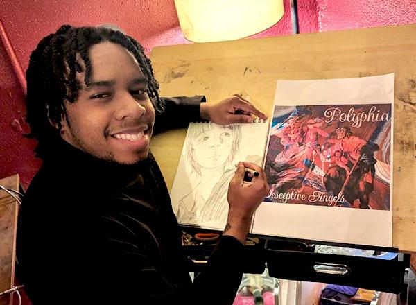 Karlos Moore, student LAND winner at his drawing board.