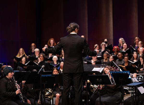 Anthony Lai directing a group of musicians. 