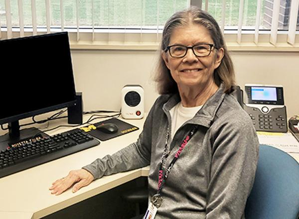 Royetta Ealba sitting at her desk.