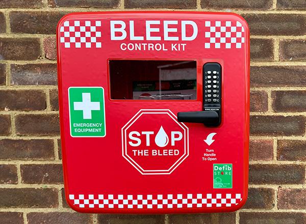 A bleed control kit attached to a brick wall in a park.