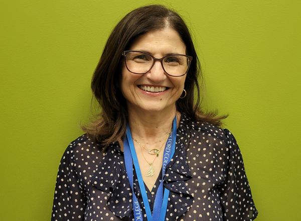 Headshot of Nahla Haidar in front of a green wall. 