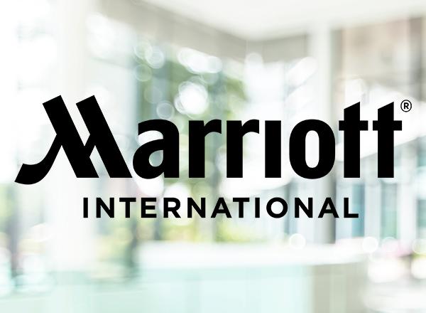 Marriott International logo on a light out of focus lobby background.