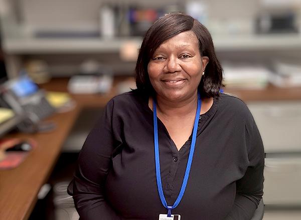 Sharon McAlpine sitting at her desk.