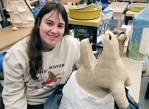 Lulu Decina posing with her sculpture. 