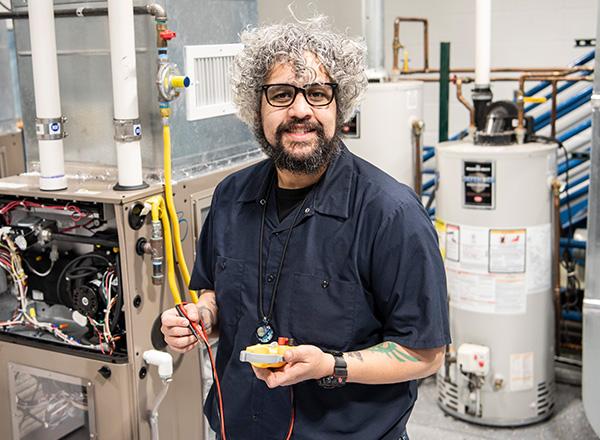 HVAC student posing with tools.