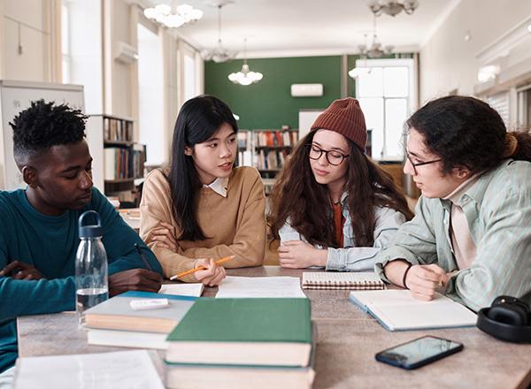 A group of diverse students studying together in a library.