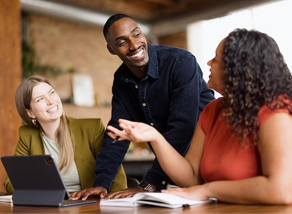  Man talking to his female colleagues in the office. Money Moves Workshop.