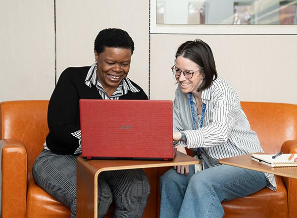 Writing Center staff member assisting student on laptop.