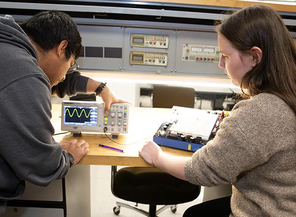 Mechatronics students looking at tool. 