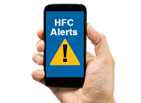 Hand holding cell phone that says HFC Alerts