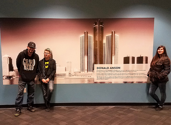 Don Anson's children next to his photo at the RenCen