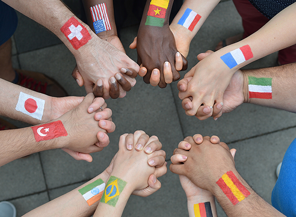 Photo of people holding hands, different international flags