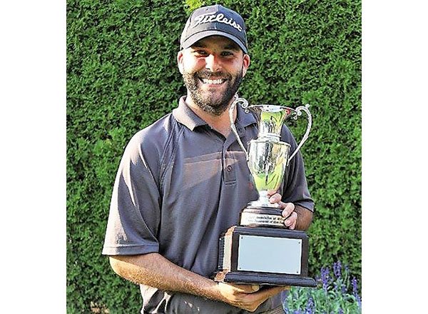 photo of Kieronski holding up golf trophy 