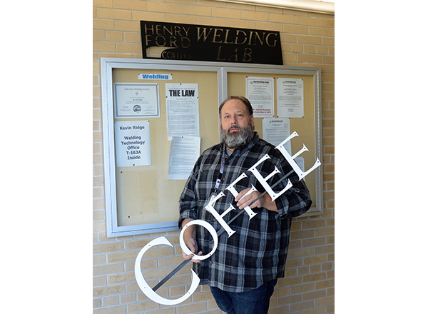 Photo of Ridge holding his coffee sign