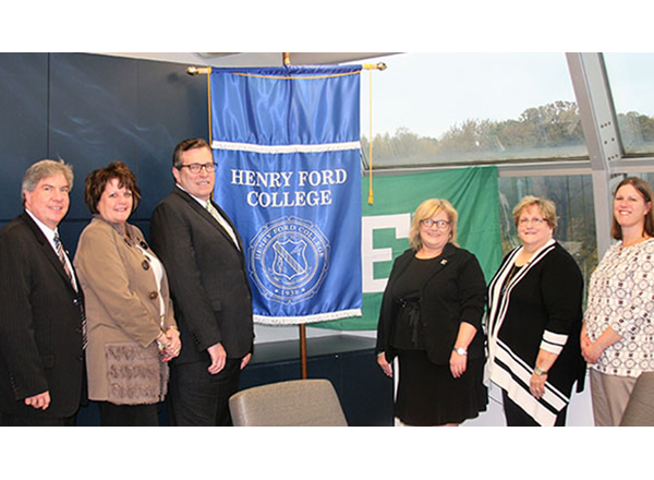 Six people standing beside HFC and EMU banners