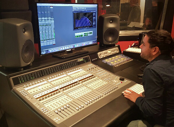 Male student sitting at a soundboard.